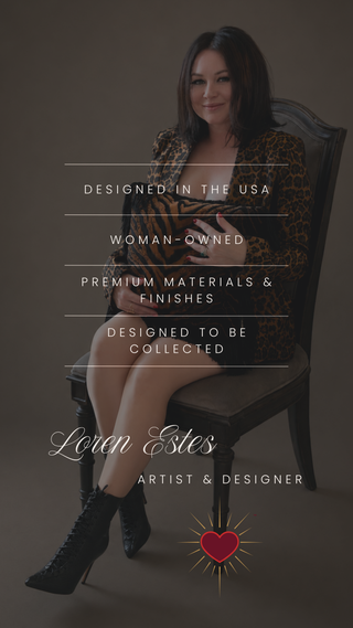 A woman seated on a dark wooden chair wearing a leopard-print top and black lace-up ankle boots, with overlaid text reading 'Designed in the USA', 'Woman-owned', 'Premium materials & finishes', 'Designed to be collected', 'Loren Estes', and 'Artist & Designer'.