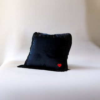 A decorative throw pillow called Sable by Loren Estes. Picture is of the back of the pillow. Black velvet with embroidered heart logo
